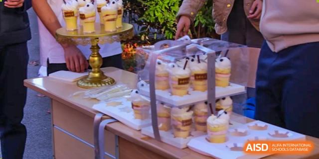 A table at Northeast Yucai Foreign Language School is set up with many small desserts in clear cups.