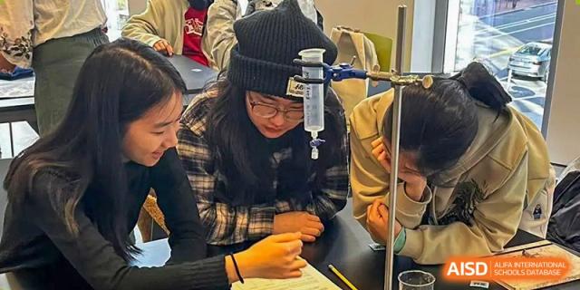 A close-up of a student from Shanghai Foreign Language School Affiliated to SISU wearing a black hat and receiving an IV drip, possibly in a sick bay or hospital room.