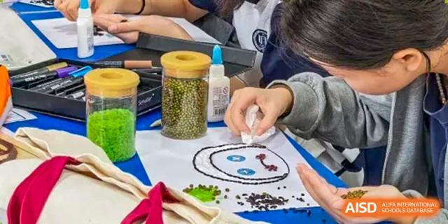Students from Shanghai Foreign Language School Affiliated to SISU engaging in a hands-on project using seeds and other natural materials to create a picture.