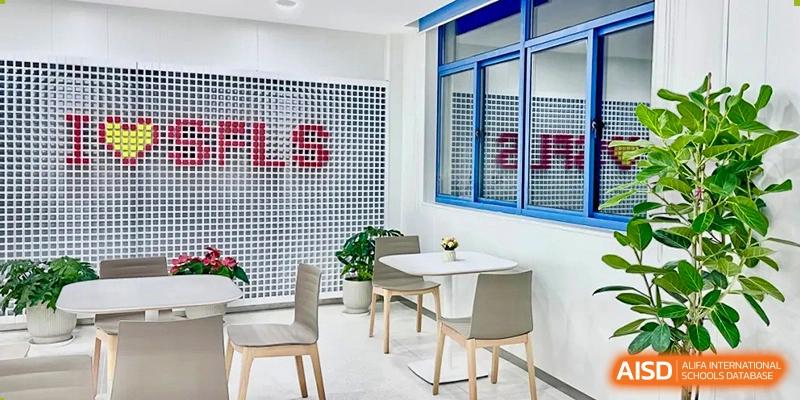 A bright, modern lounge or cafe area with small tables and chairs inside the Shanghai Foreign Language School Affiliated to SISU.