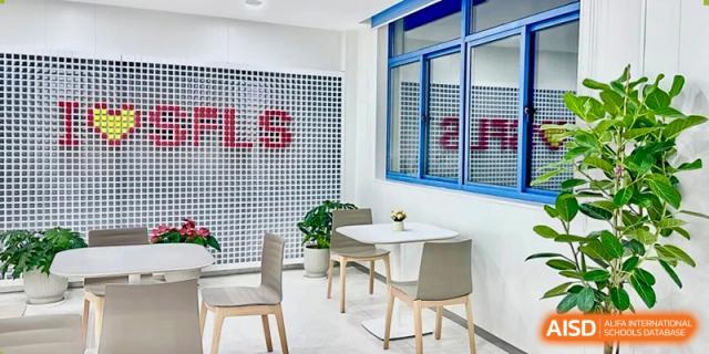 A bright, modern lounge or cafe area with small tables and chairs inside the Shanghai Foreign Language School Affiliated to SISU.