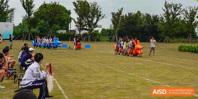 Students from Shanghai Foreign Language School Affiliated to SISU participating in a field activity or sports game on a grass field.