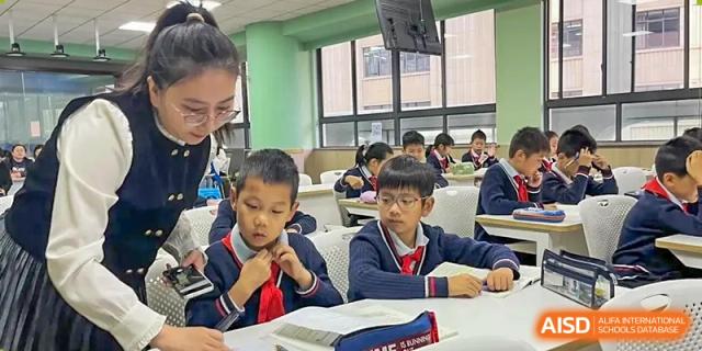A group of students are sitting at desks and studying together at Shanghai Shangde Experimental School.