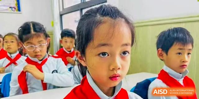 A close-up portrait of a young student with a serious expression is shown at Shanghai Shangde Experimental School.