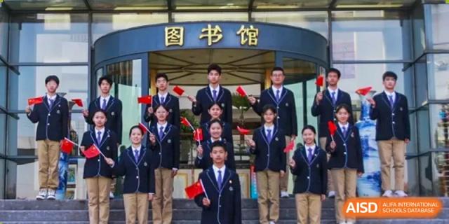 A group of students in blazers is posing for a photo in front of a sign that says "Library" at Shanghai Shangde Experimental School.