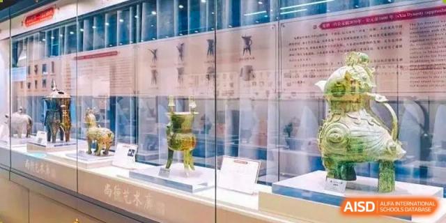 A display of ancient-looking artifacts is shown in a museum case at Shanghai Shangde Experimental School.