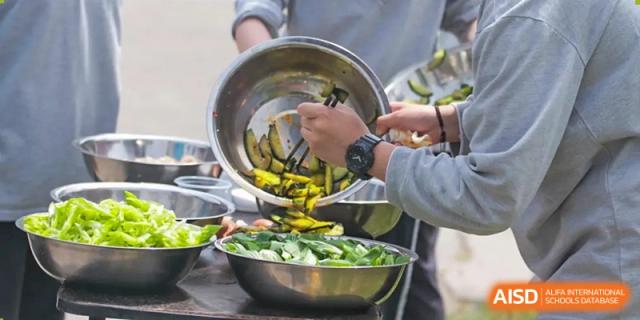 Students are preparing vegetables for a meal at Shanghai Shangde Experimental School.