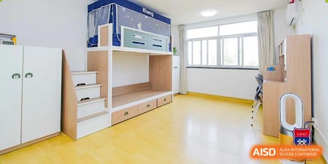 An organized dormitory room or student living area at Vanke School Pudong with built-in bunk beds and storage.