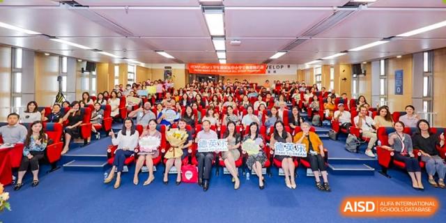 A large assembly or presentation in a school hall at Vanke School Pudong, showing many students and staff gathered.