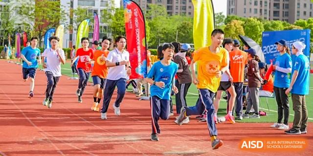 Students participating in an outdoor running event or race on a track, representing the sports activities at Vanke School Pudong.
