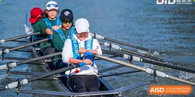 Two students in a rowing shell on the water, part of the sports program at Vanke School Pudong, both wearing life jackets.