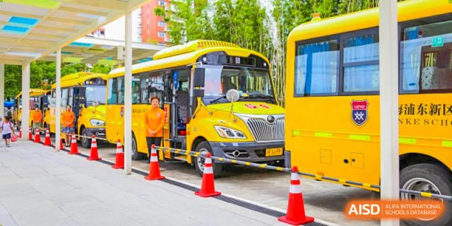 A bright yellow school bus parked outside, symbolizing student transportation services at Vanke School Pudong.