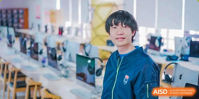 A male student from Suzhou North America High School is smiling and looking at the camera in a lab.