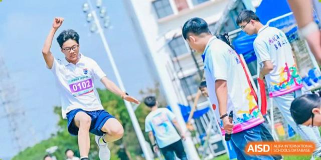 Students from Suzhou North America High School are playing a sports game on a grassy field.