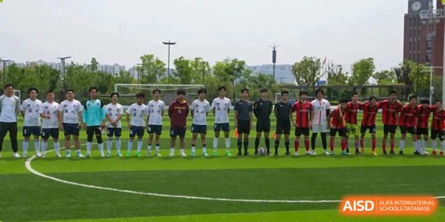 A group of students from Suzhou North America High School is lined up on a soccer field after a game.