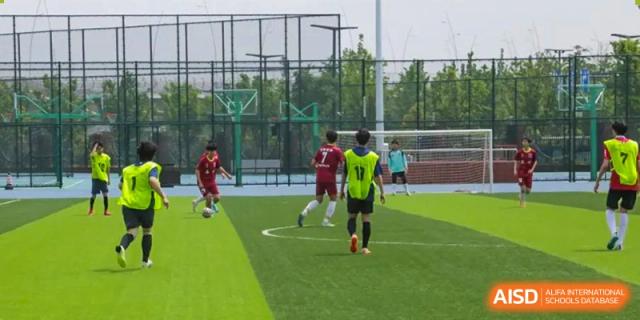 Soccer players from Suzhou North America High School are running and competing for the ball during a game.