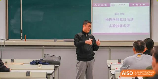 A male teacher from Tianjin Nankai High School International Department is presenting a lesson to students in a classroom.