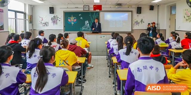 A teacher from Tianjin Nankai High School is speaking with a group of students in a classroom.