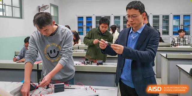 Students from Tianjin Nankai High School are working on a hands-on project with small parts, possibly a robotics or engineering class.