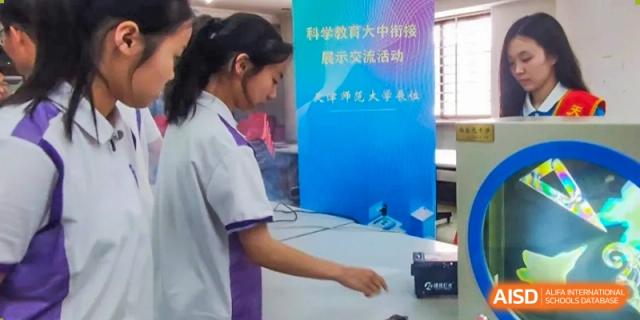 A female student from Tianjin Nankai High School  is standing next to a display board during a school science fair or exhibition.