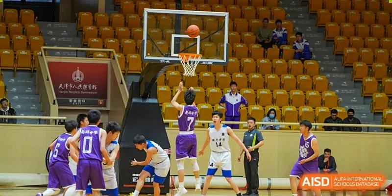 A close-up action shot of a player from the Tianjin Nankai High School  team shooting a basketball at the hoop during a game.
