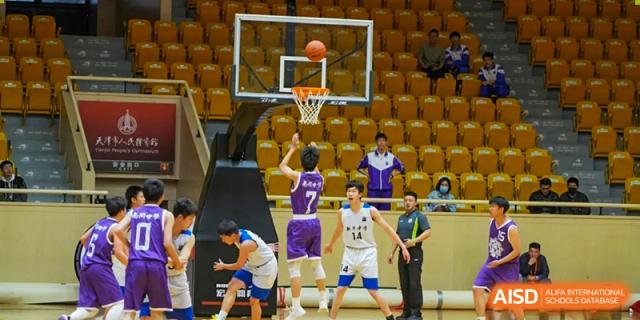 A close-up action shot of a player from the Tianjin Nankai High School  team shooting a basketball at the hoop during a game.