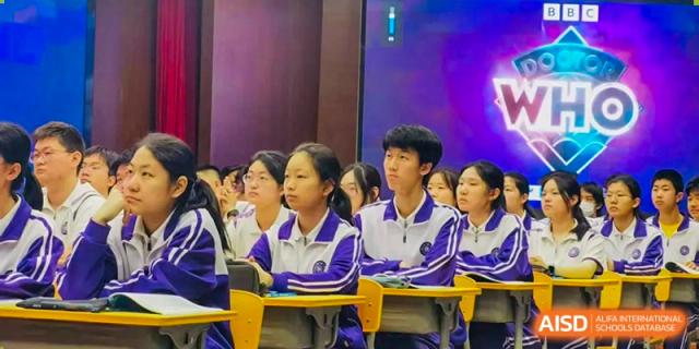 A group of students from Tianjin Nankai High School  wearing white and purple uniforms, sitting attentively in a classroom or auditorium.