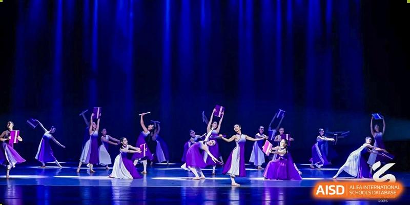 Students from Tianjin Nankai High School  performing a dance on stage, with a female dancer in a purple dress in the foreground.