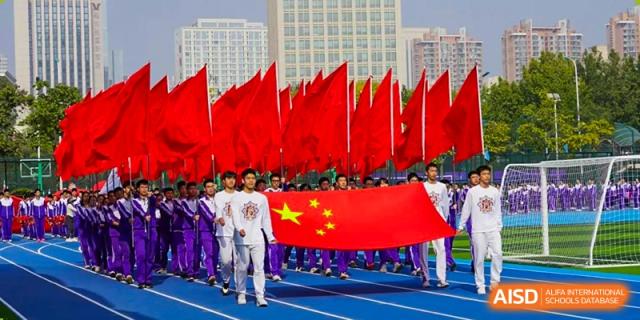 A group of students from Tianjin Nankai High School  holding the Chinese flag during a public event or parade.