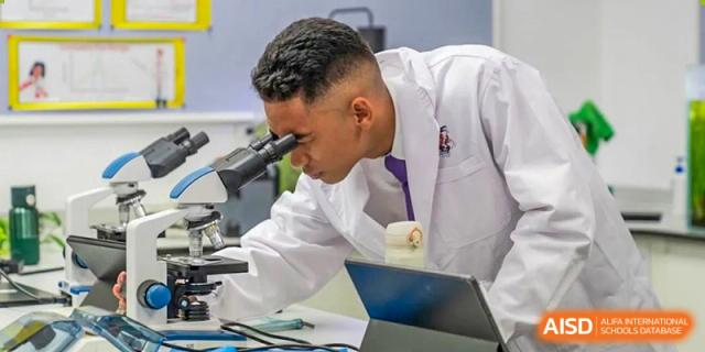 A male teacher from Wellington College International Tianjin looks through a microscope in a lab.