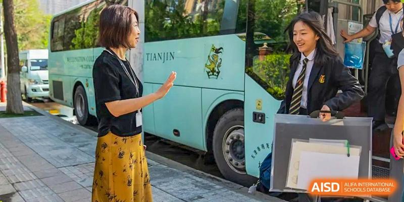 A group of students from Wellington College International Tianjin is waiting to board a bus.