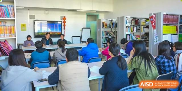 Students looking toward the front of the classroom at a presentation screen at Yang Guang Qing International School of Beijing.