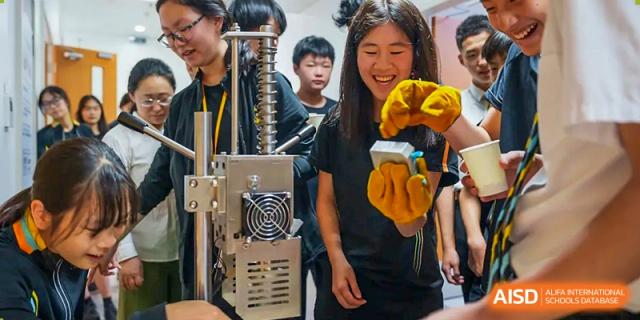 Huili School Shanghai students working together on a 3D printing machine or in a maker space.