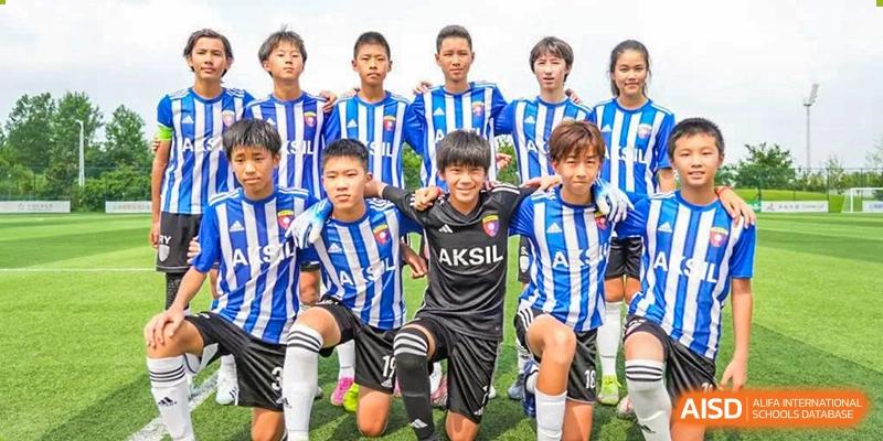 The Huili School Shanghai soccer team poses together in their blue and white striped uniforms after a competitive match.