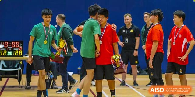 Huili School Shanghai students in sports gear congratulating each other after a competition or match.