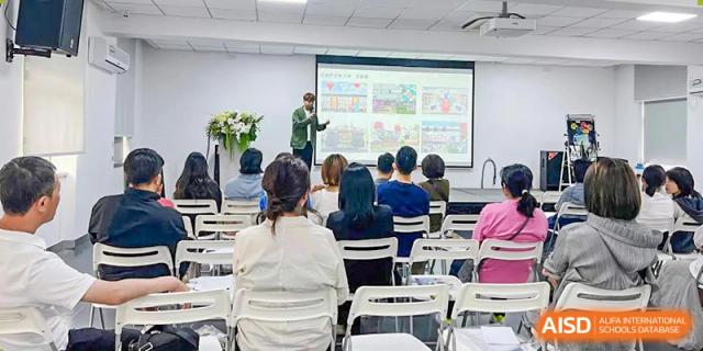 A teacher giving a presentation in a lecture hall to a group of students at Yew Wah International Education School of Shanghai Gubei.