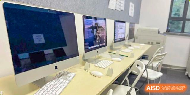 A classroom with multiple computers on desks at Yew Wah International Education School of Shanghai Gubei.