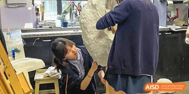 Students in a workshop, working with clay or a similar sculpting material at Yew Wah International Education School of Shanghai Gubei.