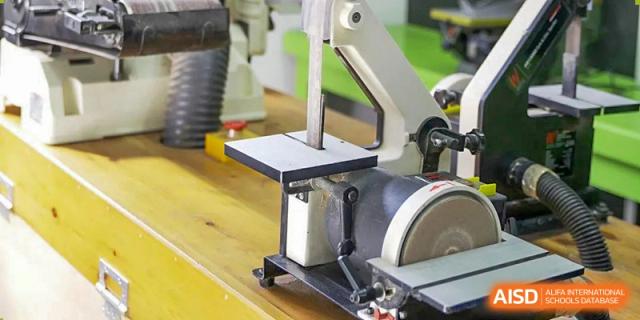 A close-up of a workshop machine, possibly a belt sander, at Yew Wah International Education School of Shanghai Gubei.
