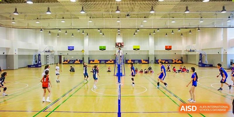 Students playing volleyball on an indoor court at Yew Wah International Education School of Shanghai Gubei.