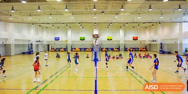 Students playing volleyball on an indoor court at Yew Wah International Education School of Shanghai Gubei.