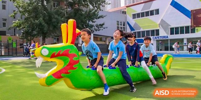 Students playing on colorful outdoor playground equipment at Yew Wah International Education School of Shanghai Gubei.