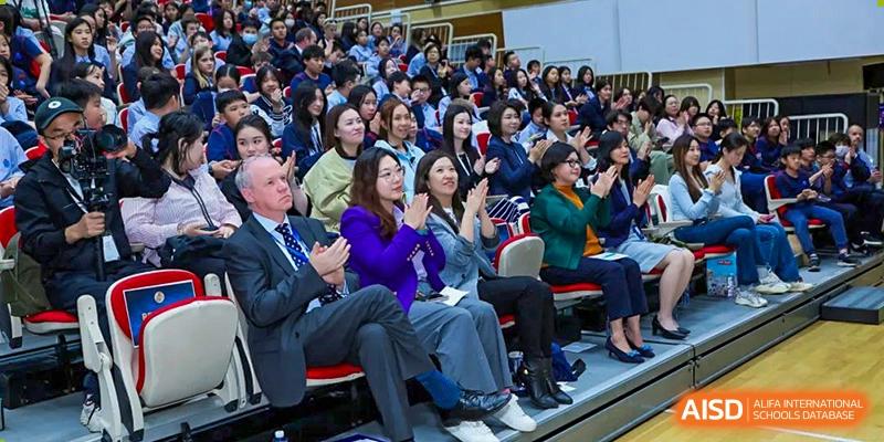 An audience of students and adults applauding at a school event at Yew Wah International Education School of Shanghai Gubei.