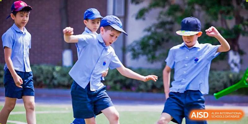 Two young students in school uniform participating in a sports activity at Yew Wah International Education School of Shanghai Gubei.