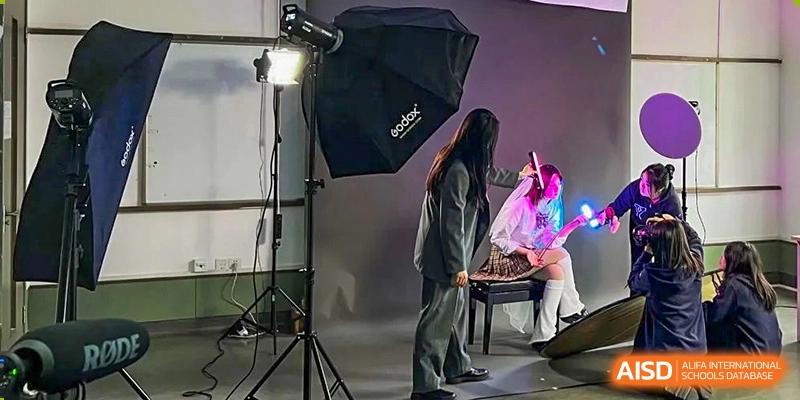 A student in a photography studio with professional lighting equipment at Yew Wah International Education School of Shanghai Gubei.