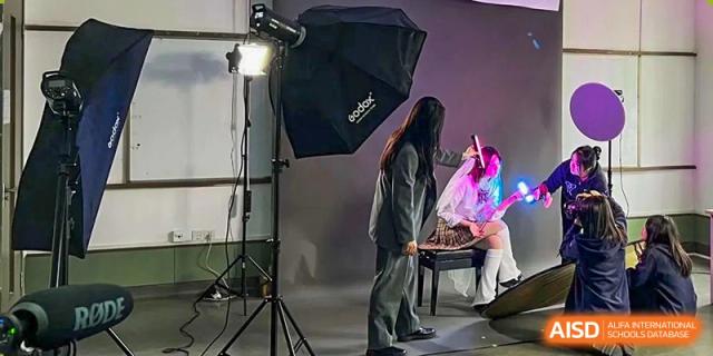 A student in a photography studio with professional lighting equipment at Yew Wah International Education School of Shanghai Gubei.