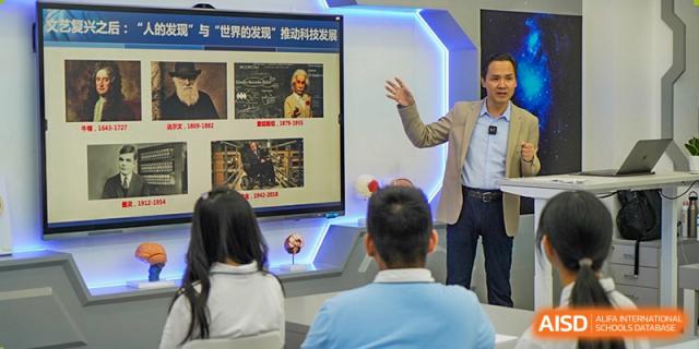 A teacher at Shenzhen Foreign Languages GBA Academy pointing to an educational display for students.