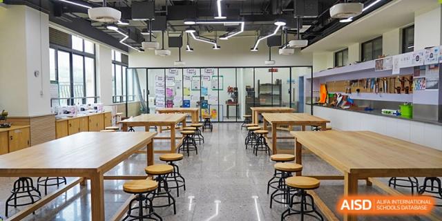 A bright and open classroom with wooden tables and chairs at Shenzhen Foreign Languages GBA Academy.