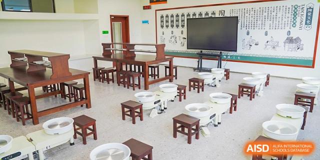 A creative space with small wooden tables and innovative stools, ready for a class at Shenzhen Foreign Languages GBA Academy.