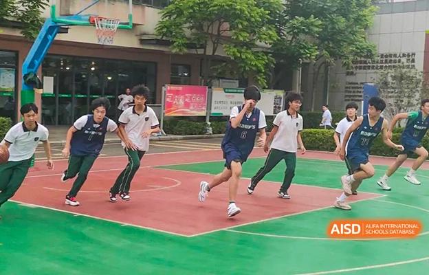 Students at Shenzhen Foreign Languages GBA Academy playing basketball on an outdoor court.